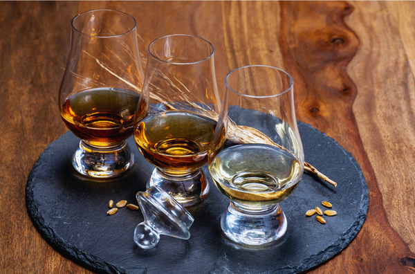 Amber whisky in clear tumblers on a slate coaster at a hidden home bar, private dining Singapore with Scotch & Sambal