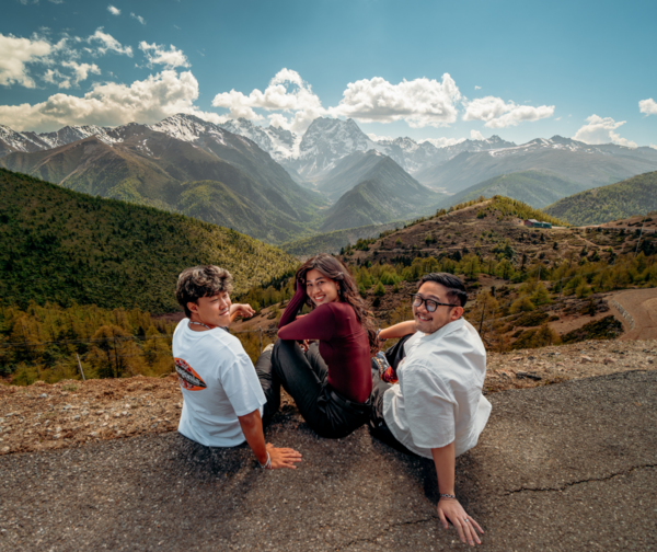 Travellers posing on a mountain viewpoint during the Shangri-La Loop with a Tibetan guide in Shangri-La