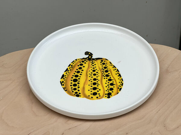 Yellow pumpkin-style ceramic plate painted on a pottery worktable at Tiong Bahru Pottery’s backyard studio, create-your-plate workshops in Singapore