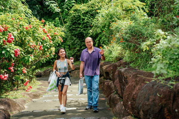 Walkers on a Wild Garden Walk (join-in) stroll along a stone path through dense flower beds in Singapore’s greenery