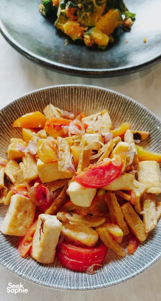 Chopped vegan vegetables and tomato salad on ceramic plates during a Traditional Manggarai cooking class in Labuan Bajo