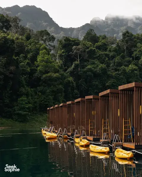 考索兰湖上,木质漂浮露营小屋旁停着独木舟,掩映在薄雾中的石灰岩山丘下