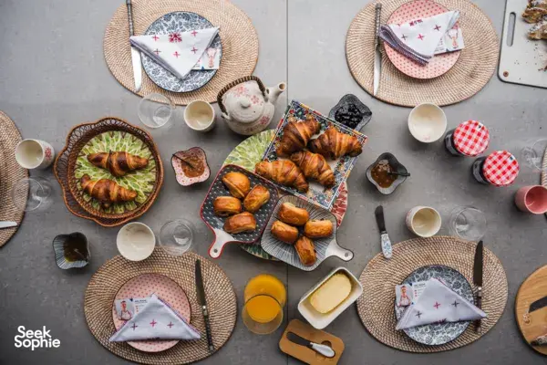 Overhead breakfast table set with croissants, cups and teapot at a French Cooking Lab session in Singapore, workshops in Singapore