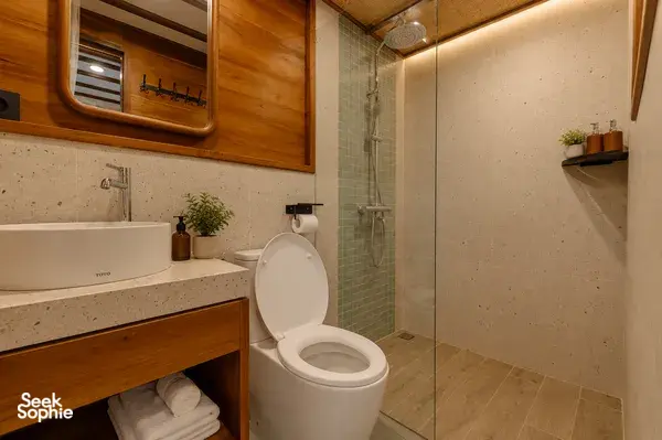 Travass Life phinisi ensuite bathroom with toilet, shower and stone vanity finishes on a Komodo shared trip, Labuan Bajo