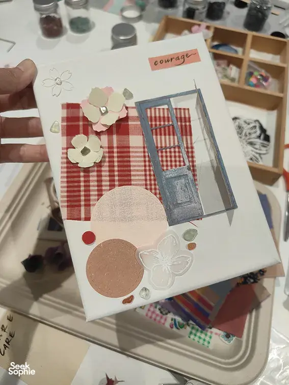 Vision board with paper flowers and the word 'courage' on a craft table during Gemstory’s hens night Singapore session