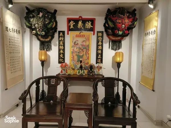 Ho Chi Minh City Chinatown lion-dance heritage room display with ornate lion heads, festive banners and a ceremonial altar