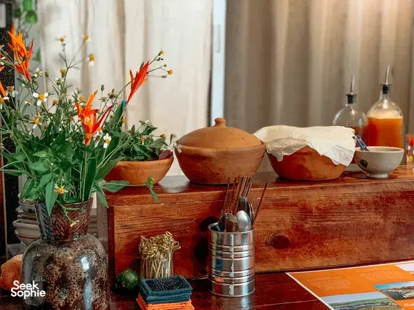 Tea service setting on a wooden table at Chan Dat Living Room in Hoi An, with terracotta pots, vases and glassware