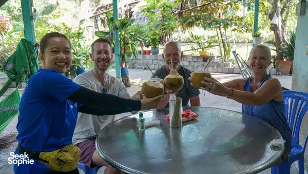 Snack break on a Mekong Island bike tour from Ho Chi Minh City, as travellers share fruit drinks at an outdoor table