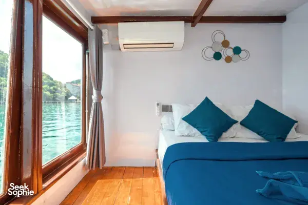 Onboard cabin on a phinisi with a window framing calm water during a private 3D2N Komodo cruise, near Labuan Bajo