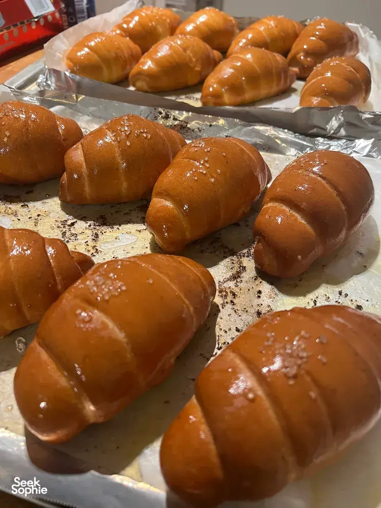 Freshly baked shio pan rolls cooling on foil-lined trays at a hands-on bread class with The Daily Staples — workshops in Singapore