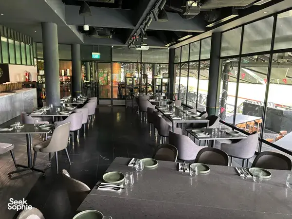 Long dining tables with place settings and glassware in a modern Singapore space for team local produce cooking challenges
