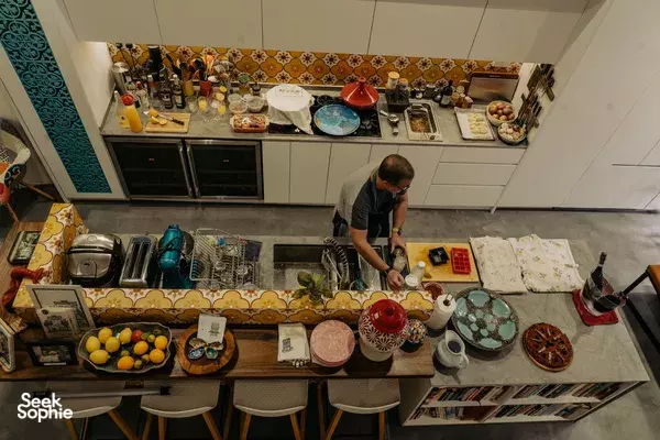 Chef arranges Mediterranean ingredients on a counter in a Peranakan shophouse kitchen for private dining Singapore