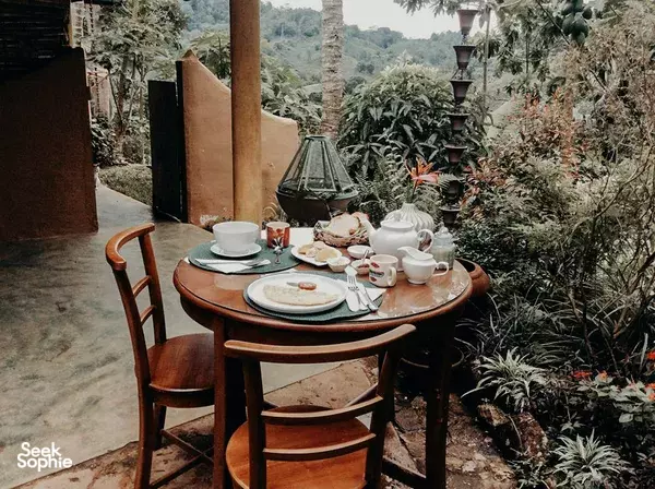 Outdoor breakfast set on a wooden terrace table surrounded by tropical greenery near Natural Mystic Sanctuary in Sinharaja Forest
