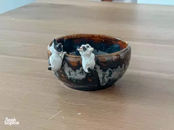 Glazed ceramic bowl with small cat figurines on a workbench at Tiong Bahru Pottery studio in Singapore — workshops in Singapore