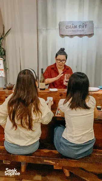 Host-led wine tasting at Chan Dat Living Room in Hoi An, with a seated host facing guests at a set table