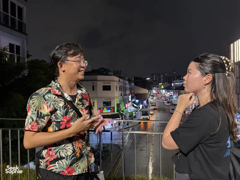 Indie Singapore Tours guide chatting with a traveller during a private night walk through Geylang, Singapore; Singapore hidden gems