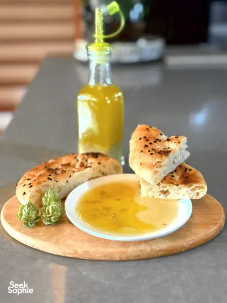 Golden dip in a bowl with warm bread pieces on a wooden platter, plus an oil bottle, at a Singapore workshop — workshops in Singapore