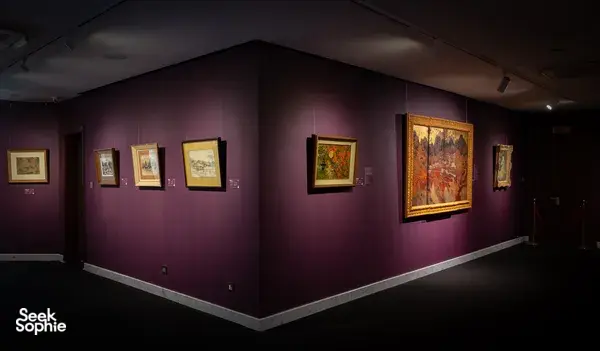 Framed Vietnamese artworks displayed along purple gallery walls inside Quang San Art Museum in Ho Chi Minh City
