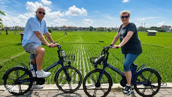 Electric e-bikes paused beside rows of Subak rice fields near Sanur, with Green Bikes Bali guides on a local cycling route