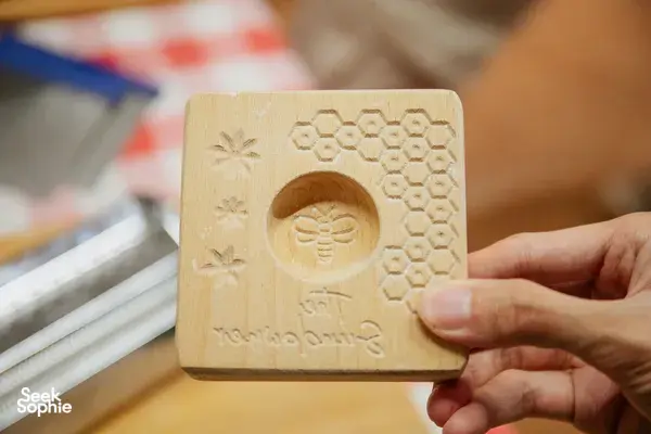Bee and honeycomb carved pasta stamp held in hands in Singapore during a pasta-making workshop — workshops in Singapore