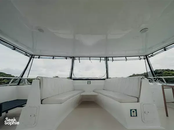 MS Eternity catamaran lounge in Singapore, U-shaped white seating beneath an open canopy with the sea and sky beyond