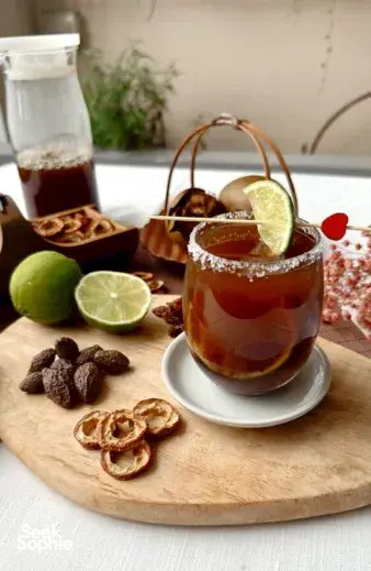 Lime-topped TCM-inspired mocktails with dried ginger and citrus slices arranged on a wooden board for mocktails workshops in Singapore