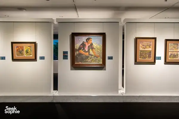 Lukisan berbingkai berjajar di dinding putih Museum Seni Quang San di Ho Chi Minh City, ditata untuk tur seni Vietnam dengan pemandu