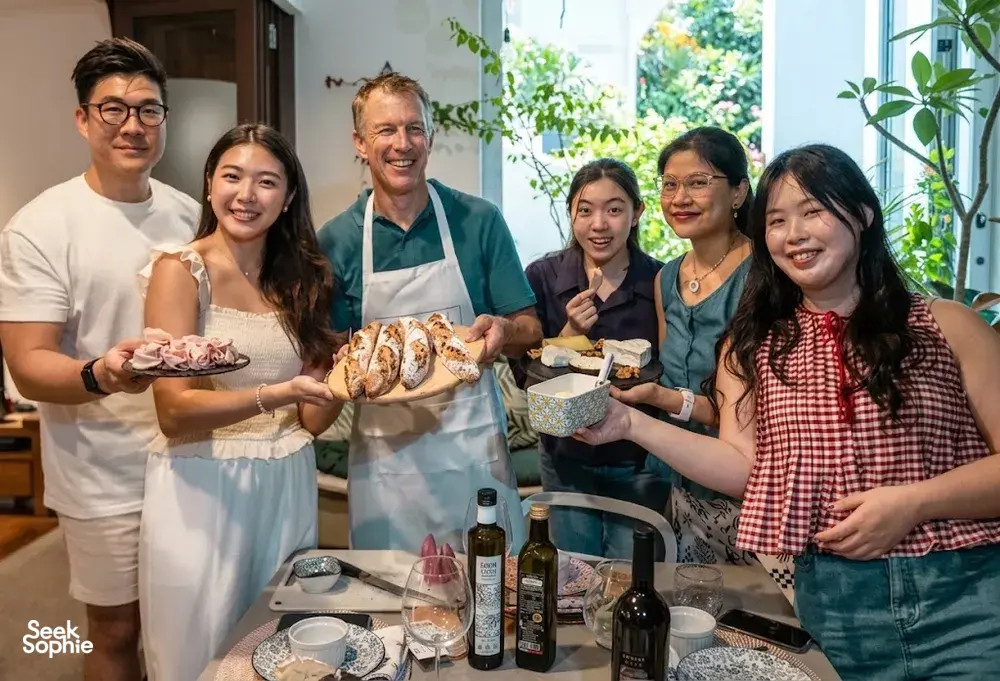 Travellers with a French chef shaping baguettes in a Singapore kitchen for a private group baking class — workshops in Singapore