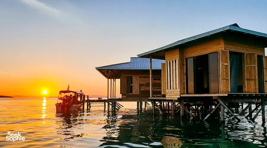 Sunset view of an overwater stilt sea lodge on the pier at Semporna, a calm base for 2D1N diving adventures