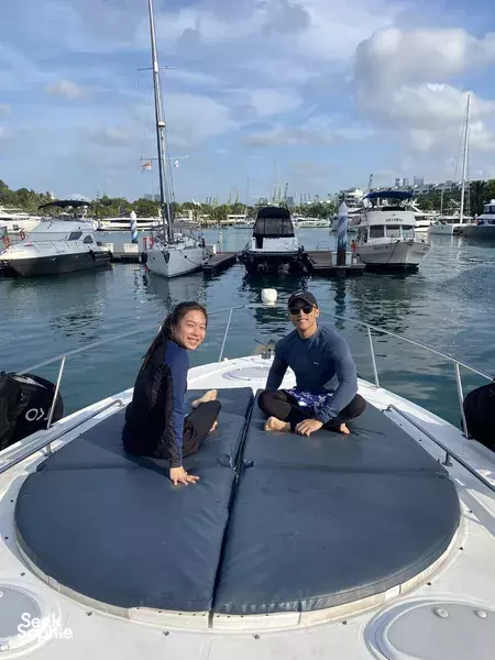 Two travellers relaxing on the bow of a yacht at a Singapore marina during a jetboard and efoil day adventure