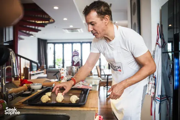 French Cooking Lab chef placing shaped croissants on a baking tray in a bright Singapore kitchen session