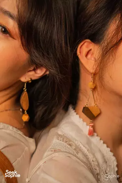 Wooden drop-and-hoop earrings on two participants’ ears, made during a woodworking workshop in Singapore, workshops in Singapore