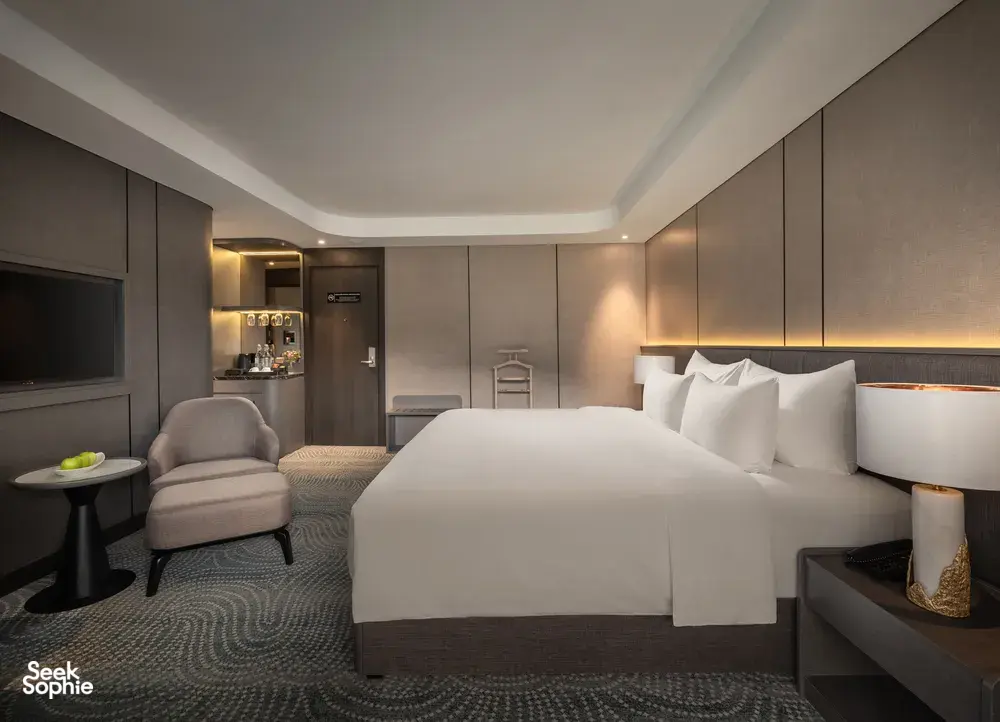 Doris Cruise cabin with king-size bed, sofa chair and bedside lighting on a 2D1N Lan Ha Bay cruise in Vietnam