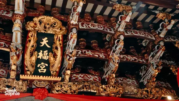 Ornate temple altar with gold dragon carvings and patterned statues under Chinese characters, part of Singapore hidden gems
