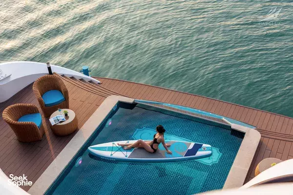 Relaxing in the onboard spa pool on a Halong Bay cruise deck, with the sea stretching behind and Lyra Cruise Collection