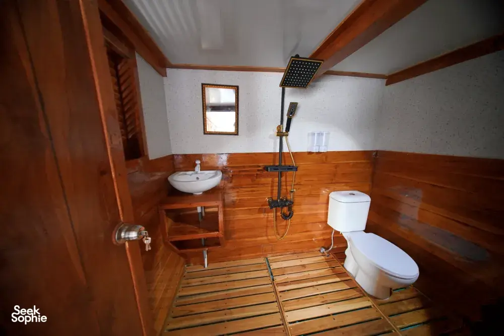 Wood-panelled boat bathroom with sink, shower and toilet for a join-in 3D2N Komodo trip, near Komodo Island