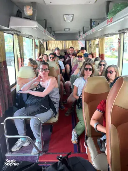 Passengers on a Son Tung Express coach, seated along the aisle during the Cat Ba to Halong Bay transfer journey