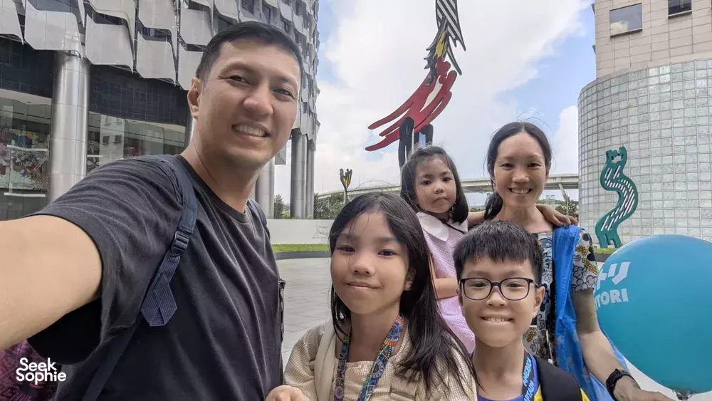 Smiling guide with children pose outdoors in Singapore during a Kampong Gelam heritage adventure, uncovering Singapore hidden gems