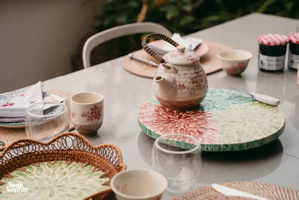 Tea set and colourful place settings on a Singapore balcony table, with croissants and small bowls ready for a class tasting