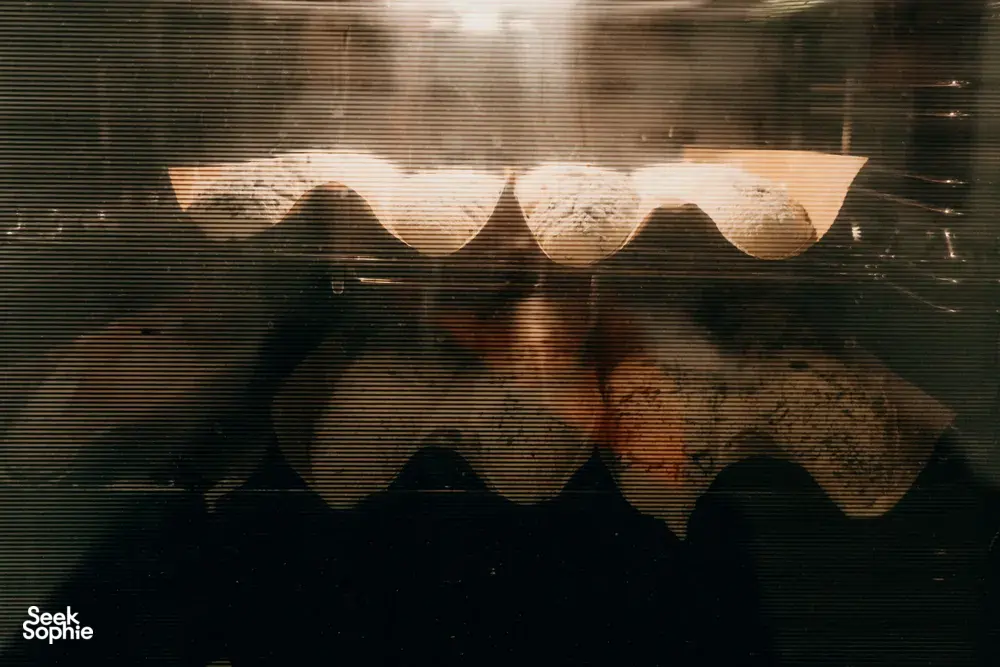 Golden baguettes baking in a windowed oven in a cosy loft in Singapore, part of French Cooking Lab workshops in Singapore
