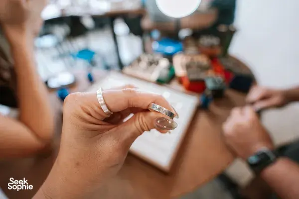 Close-up of hands holding a silver couple ring during the making process at Fat Anvil Studios in Singapore, workshops in Singapore