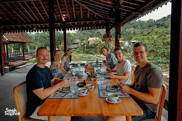 Balinese vegan cooking class group dining at Anandinii Organic Garden & Kitchen in Sidemen, Bali, beneath an open pavilion