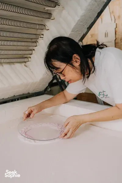 Glass centrepiece workshop at Art Glass Centre in Singapore: a woman arranging small glass pieces in a bowl — workshops in Singapore