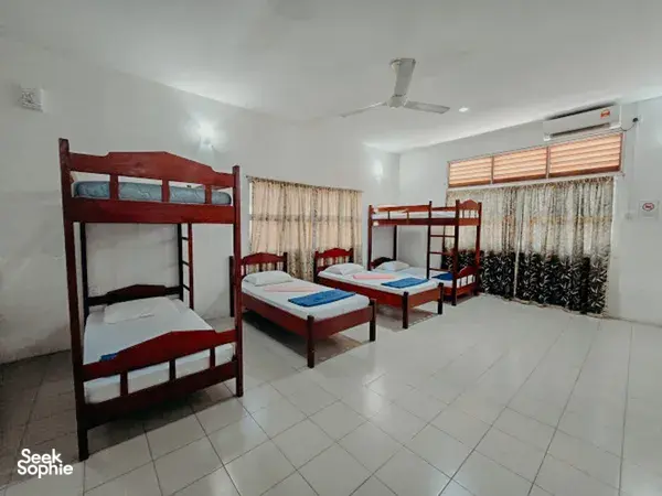 KOPEL Kinabatangan dorm in Sandakan with bunk beds, sheer curtains, and an air conditioner, for a Kinabatangan River safari