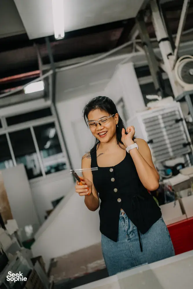 Tan Sock Fong holds a clear glass piece during a glass centrepiece workshop at Art Glass Centre, workshops in Singapore