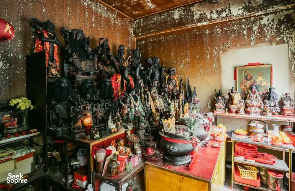 Interior toko yang penuh dengan figurina, mangkuk, dan lilin di dekat Jalan Besar, dijelajahi bersama Hidden Heritage di Singapura — hidden gems Singapura