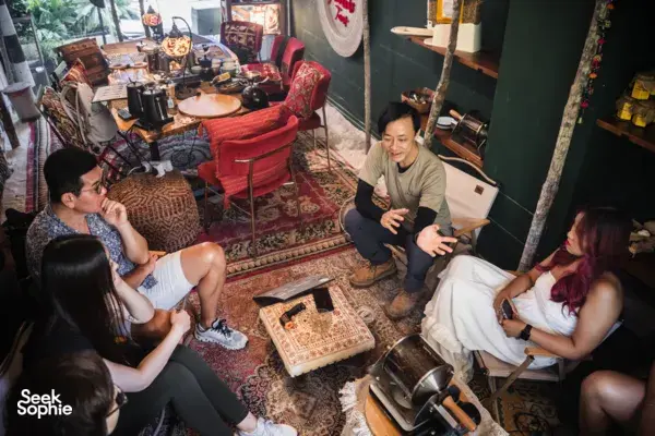 Guests gather by coffee-making equipment while an instructor explains tasting for bagel brunch in Singapore, workshops in Singapore