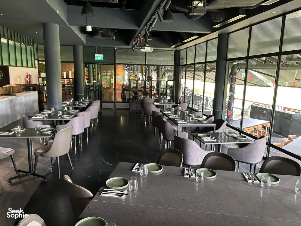 Long dining tables with place settings and glassware in a modern Singapore space for team local produce cooking challenges
