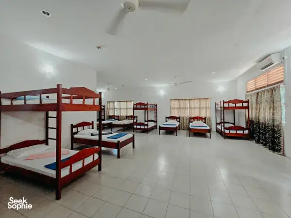 KOPEL Kinabatangan accommodation dorm with rows of bunk beds, tiled floor and windows with curtains—ready for 3D2N on Kinabatangan River