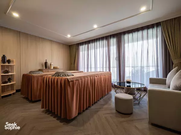 Doria Cruise luxury cabin room with draped bed, sheer curtains and lounge sofa for 2D1N stays in Halong Bay